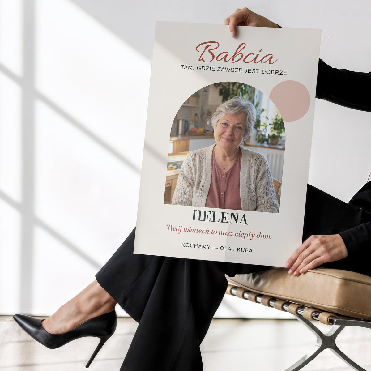 Personalizowany plakat BABCIA — CIEPŁY DOM bez ramki trzymany w dłoniach, z własnym zdjęciem i tekstem | C-PL-HEART-23-2130-NF