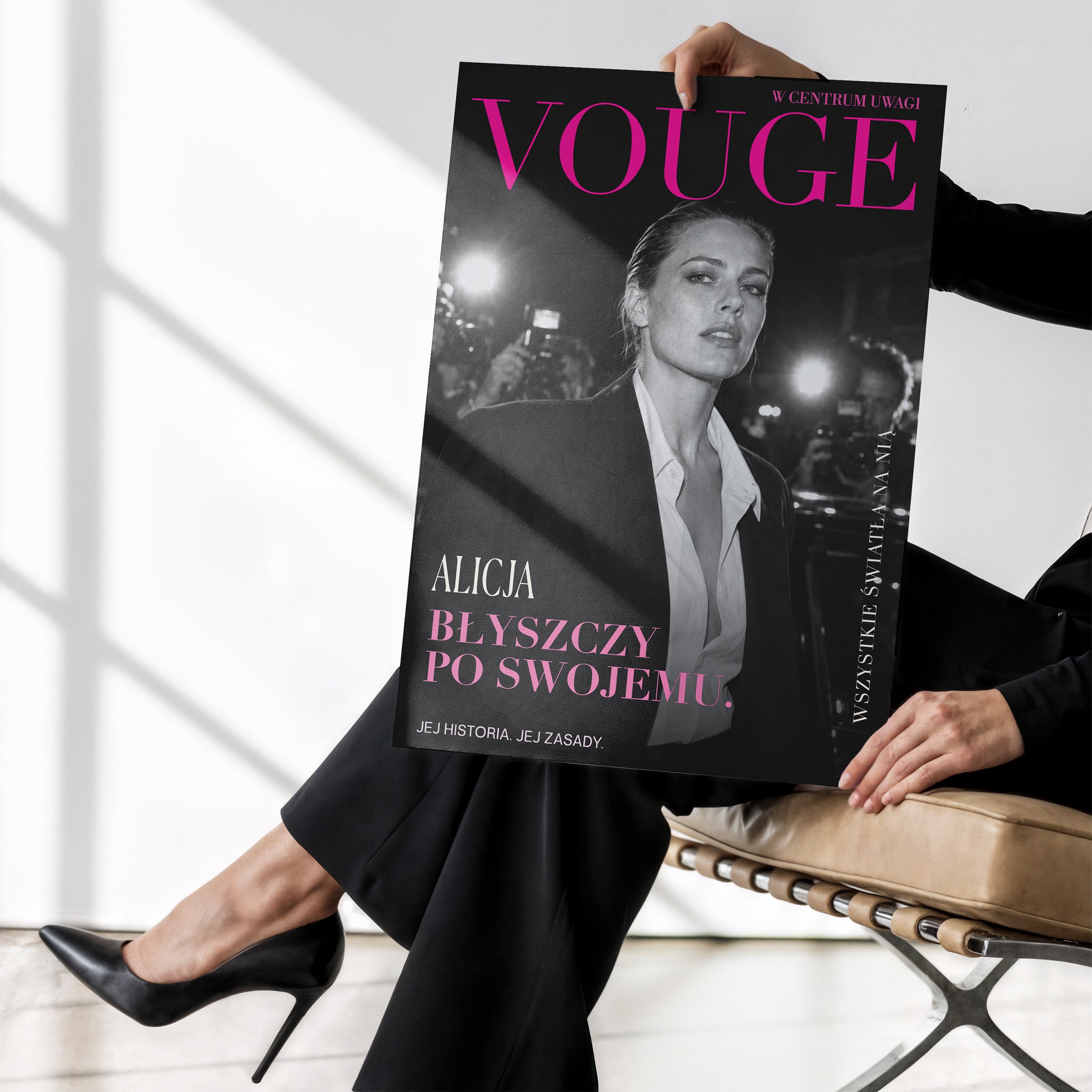 Personalizowany plakat Vouge Flesze bez ramki, trzymany w dłoniach. Czarno-biały portret i fuksjowy tytuł tworzą osobistą okładkę ze zdjęciem.