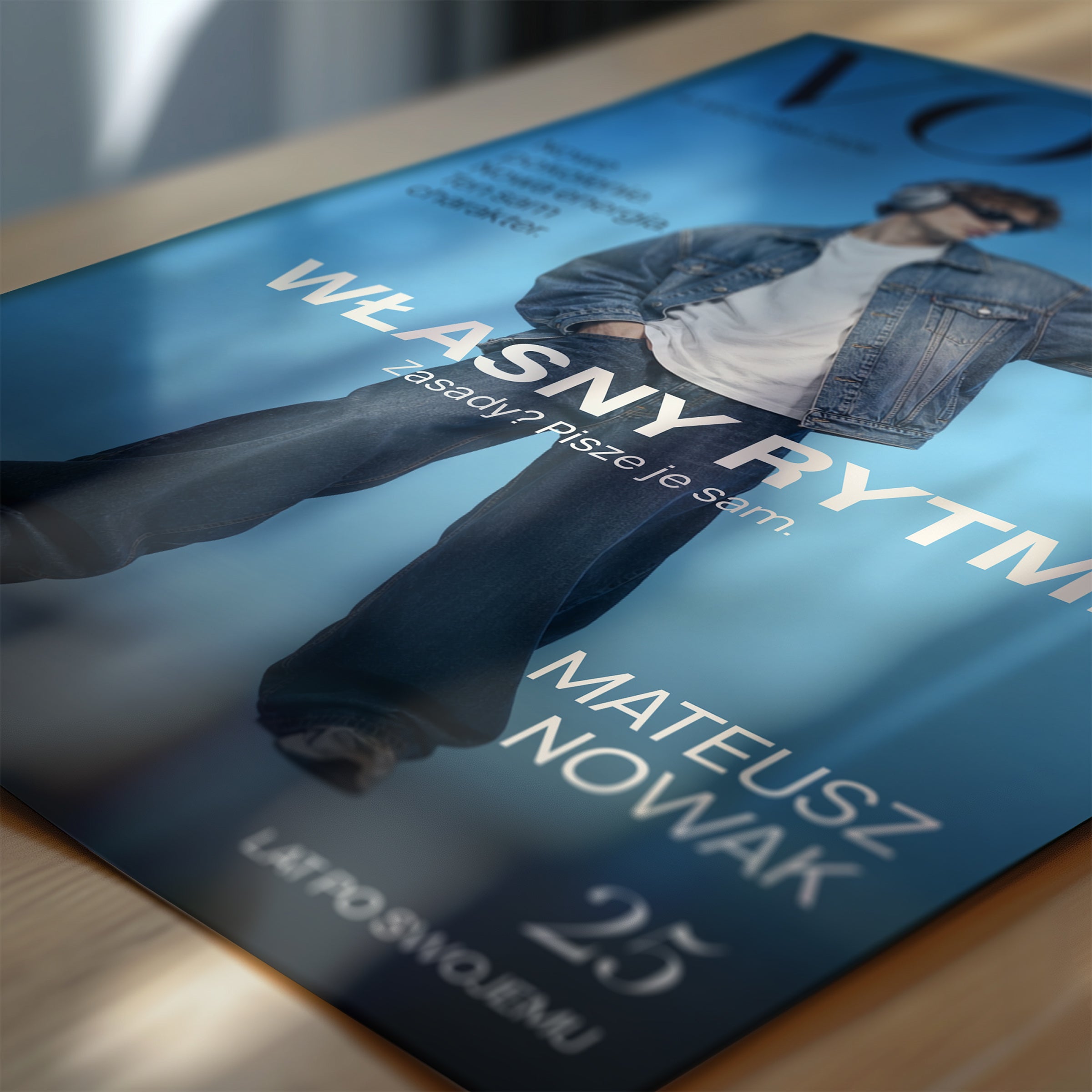 Personalizowany plakat Vouge Własny Rytm w zbliżeniu pokazującym druk. Niebieskie tło i szerokie jasne hasło tworzą osobistą okładkę ze zdjęciem.
