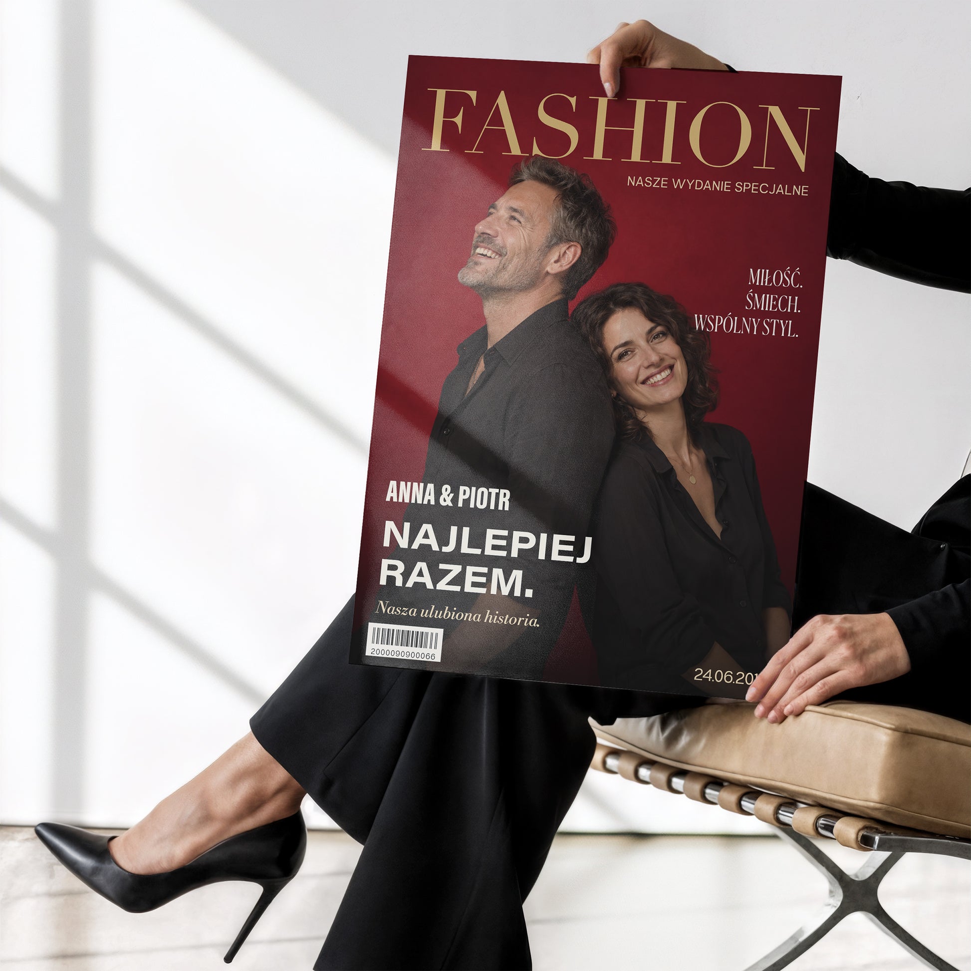 Personalizowany plakat Fashion Dla Pary bez ramki, trzymany w dłoniach. Czerwone tło, złocisty tytuł i wspólny portret tworzą osobistą okładkę ze zdjęciem.
