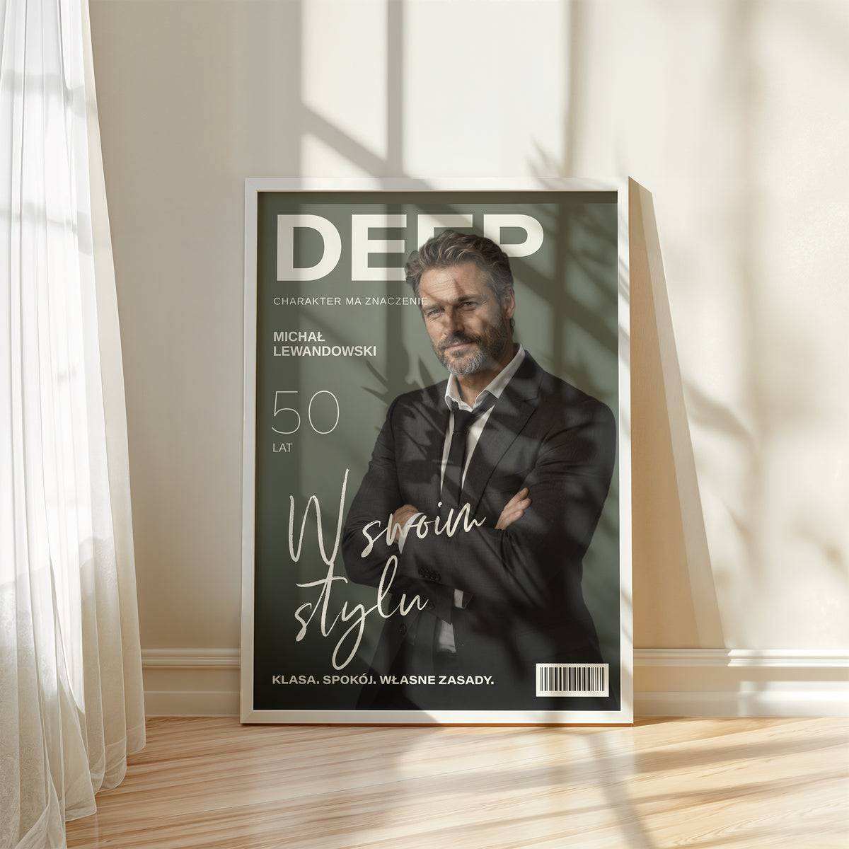 Personalizowany plakat DEEP — W SWOIM STYLU w białej ramce przy oknie, z własnym portretem, imieniem i napisami na okładce magazynu.
