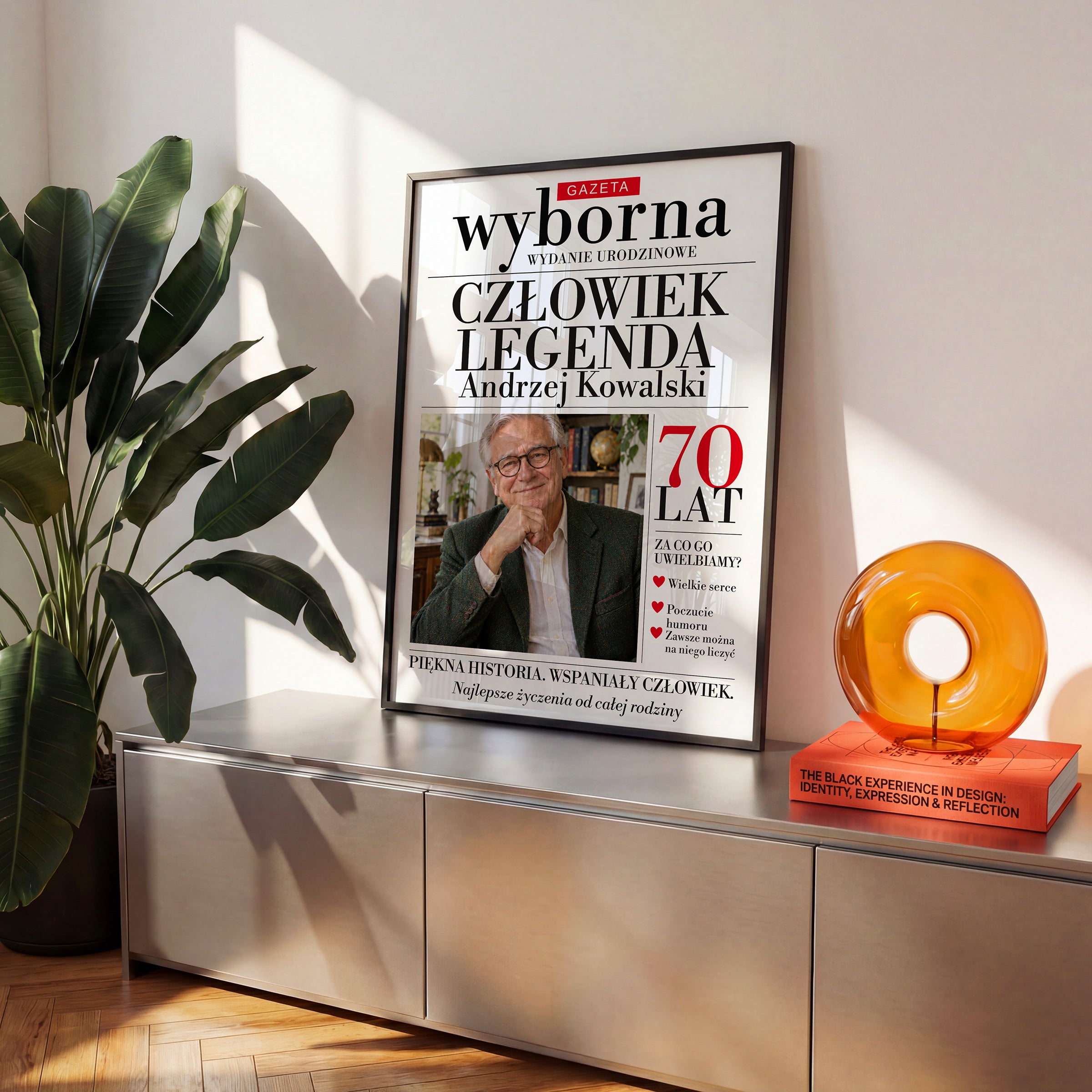 Personalizowany plakat GAZETA WYBORNA — ON w czarnej ramce na komodzie, z własnym zdjęciem i tekstem | C-PL-GAZ-14-2130-NF