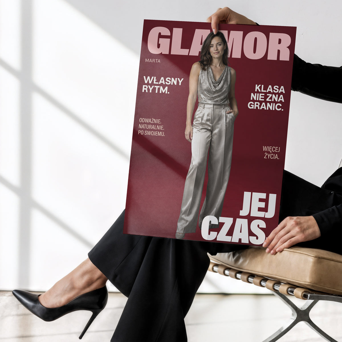 Personalizowany plakat GLAMOR bez ramki, trzymany w dłoniach. Bordowe tło, portret i jasne napisy na modowej okładce portretowej.
