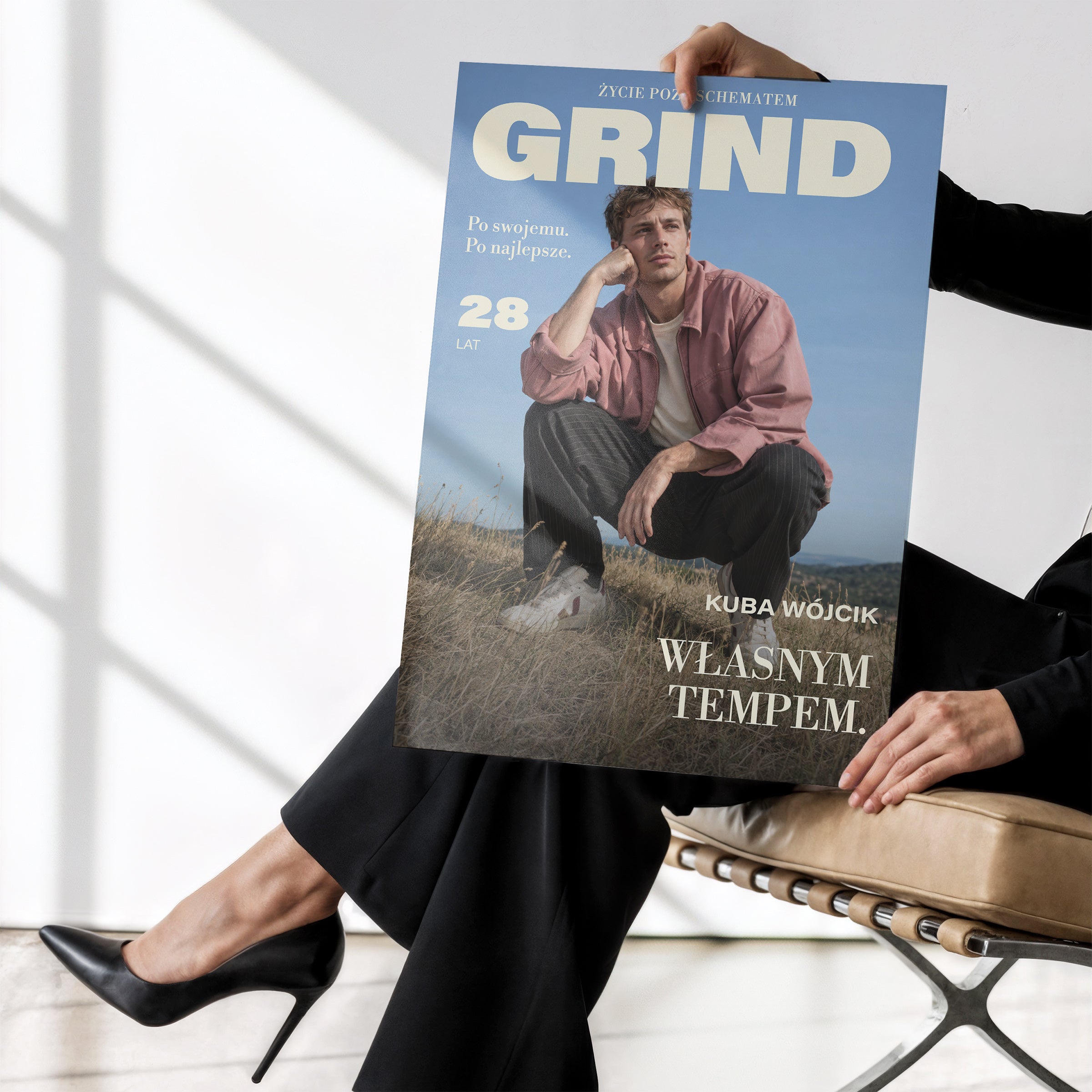 Personalizowany plakat GRIND — WŁASNYM TEMPEM bez ramki, trzymany w dłoniach, z własnym portretem, imieniem i napisami na okładce magazynu.