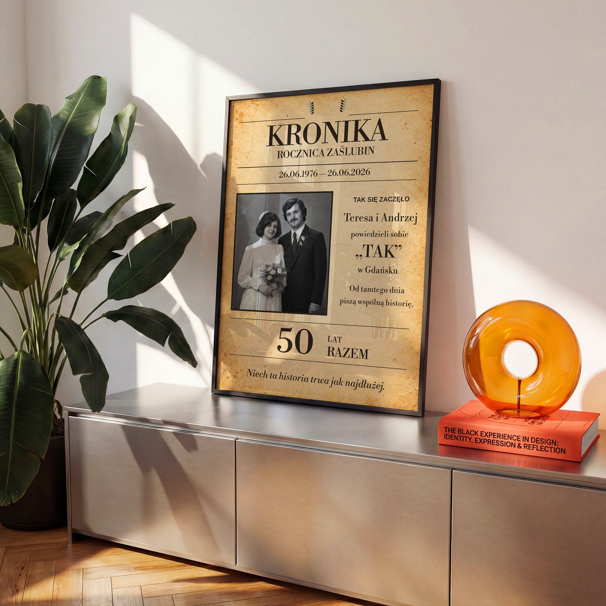 Personalizowany plakat KRONIKA ZAŚLUBIN w czarnej ramce na komodzie, z własnym zdjęciem i tekstem | C-PL-HEART-13-2130-NF