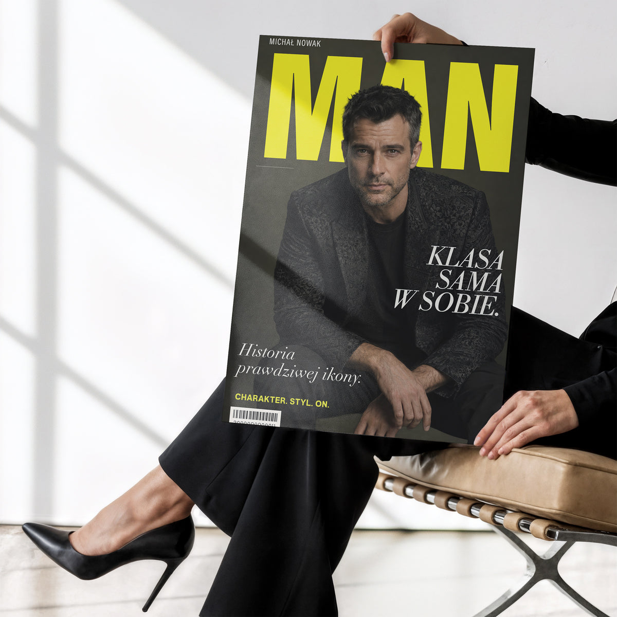 Personalizowany plakat MAN bez ramki, trzymany w dłoniach. Żółty tytuł i portret na ciemnym tle na modowej okładce portretowej.