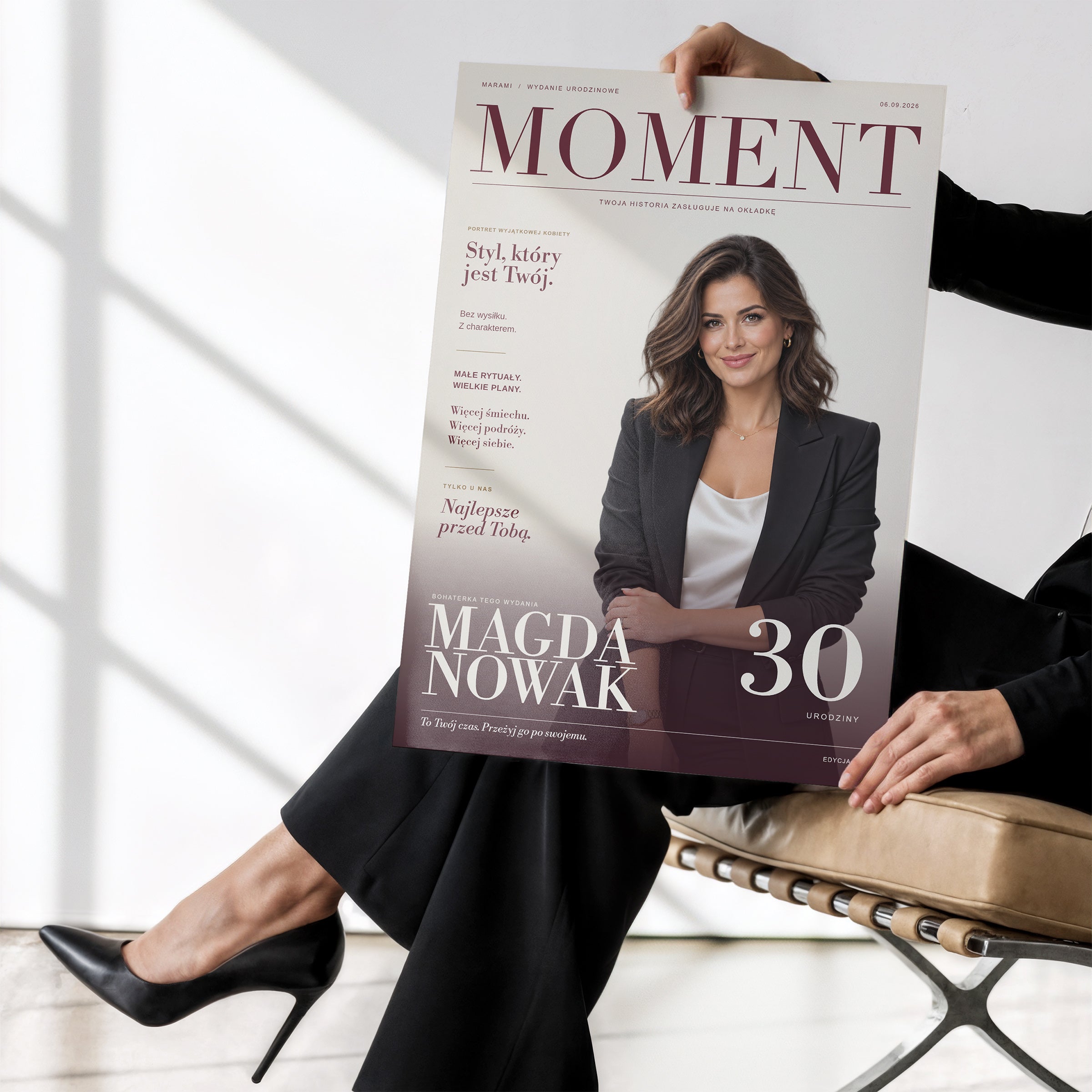 Plakat urodzinowy MOMENT bez ramki, trzymany w dłoniach. C-PL-COVMAG-3-2130-NF