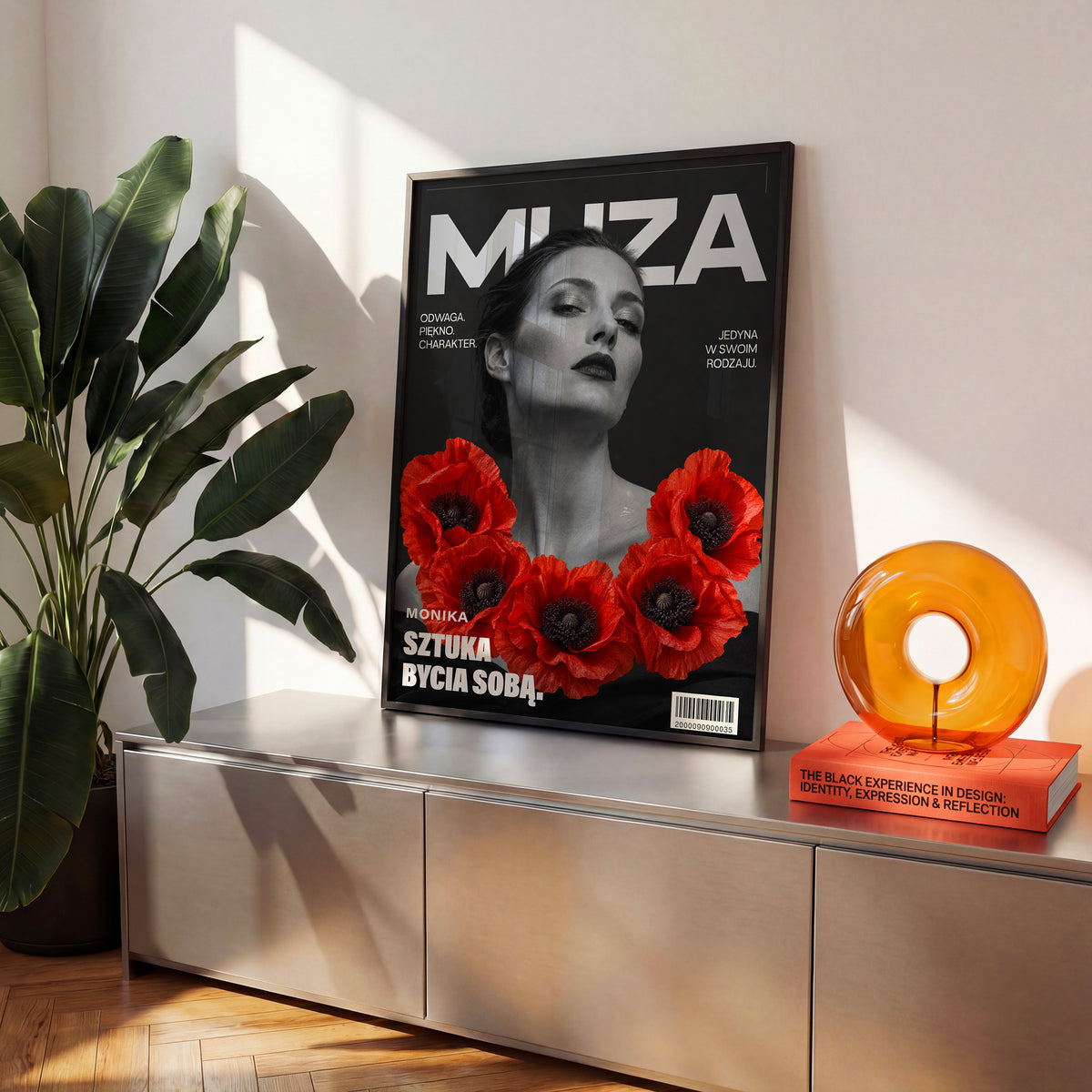 Personalizowany plakat MUZA w czarnej ramce na komodzie. Czarno-biały portret i czerwone maki na modowej okładce portretowej.