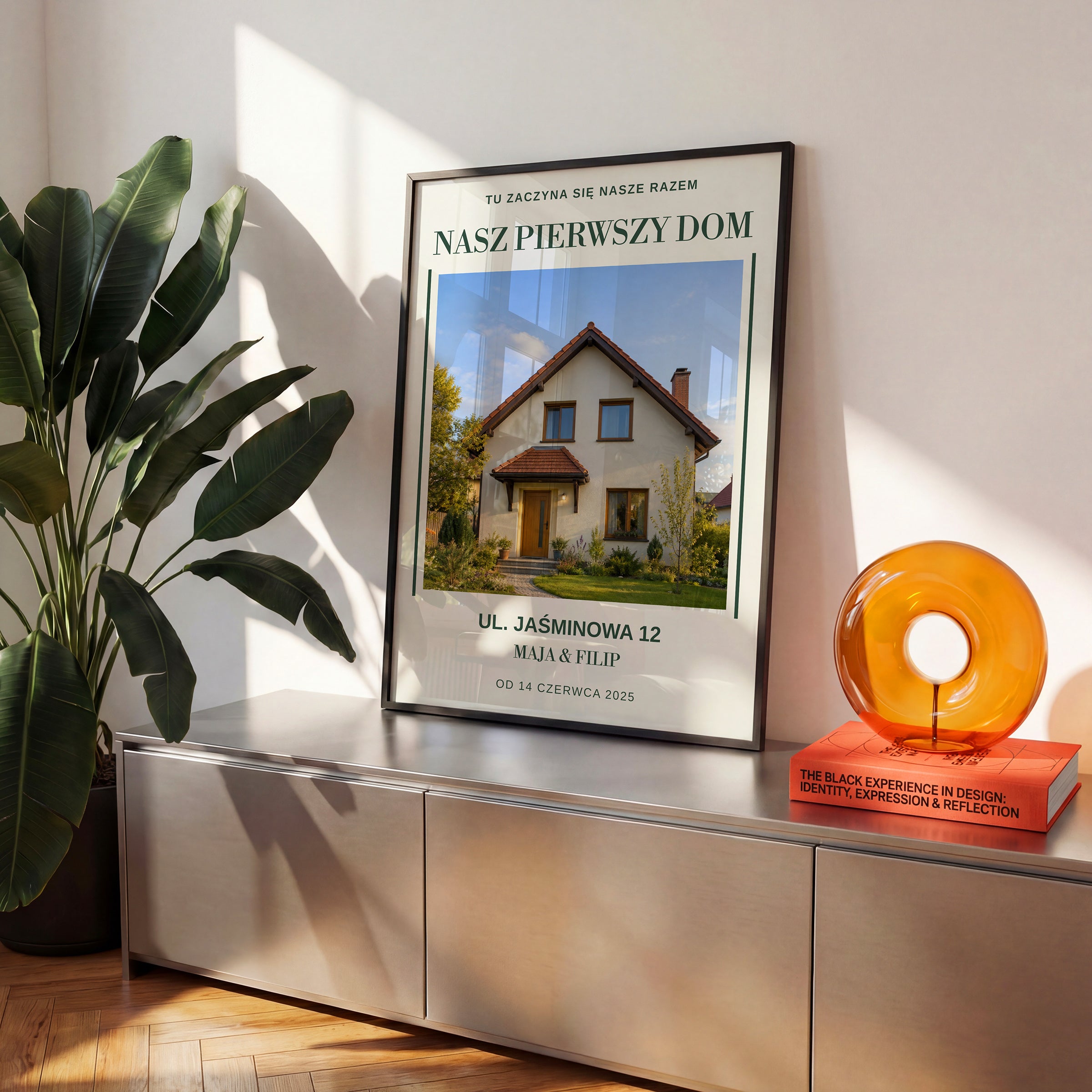 Personalizowany plakat NASZ PIERWSZY DOM w czarnej ramce na komodzie, z własnym zdjęciem i tekstem | C-PL-HEART-26-2130-NF