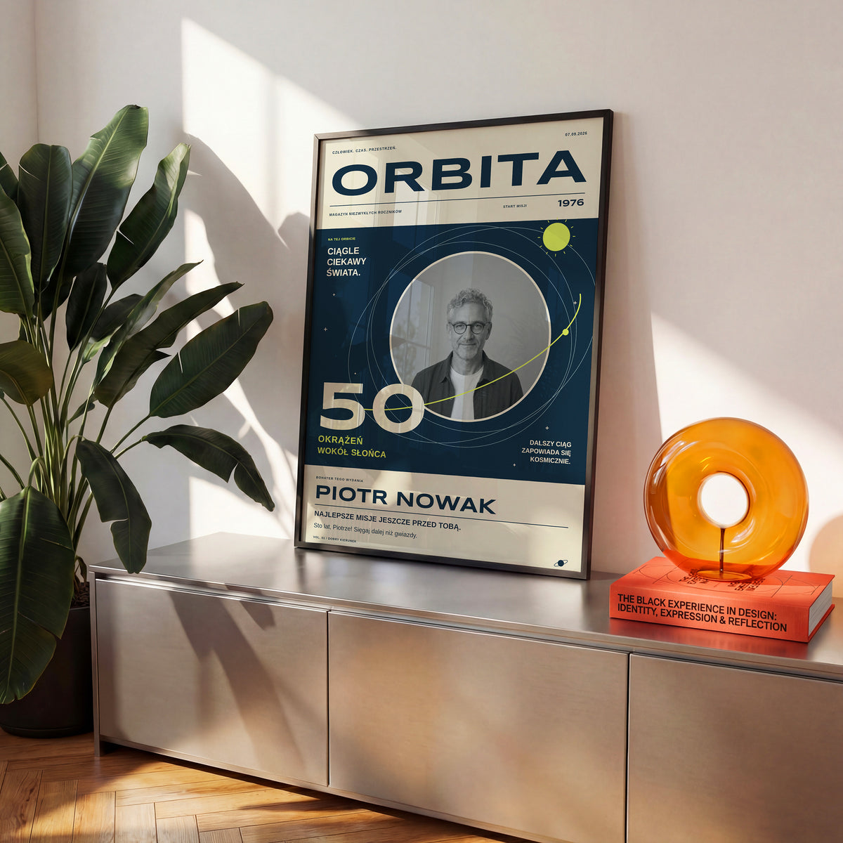 Plakat ORBITA w czarnej ramce na komodzie, granatowa okładka z limonkowymi orbitami i własnym imieniem | C-PL-COVMAG-9-2130-NF