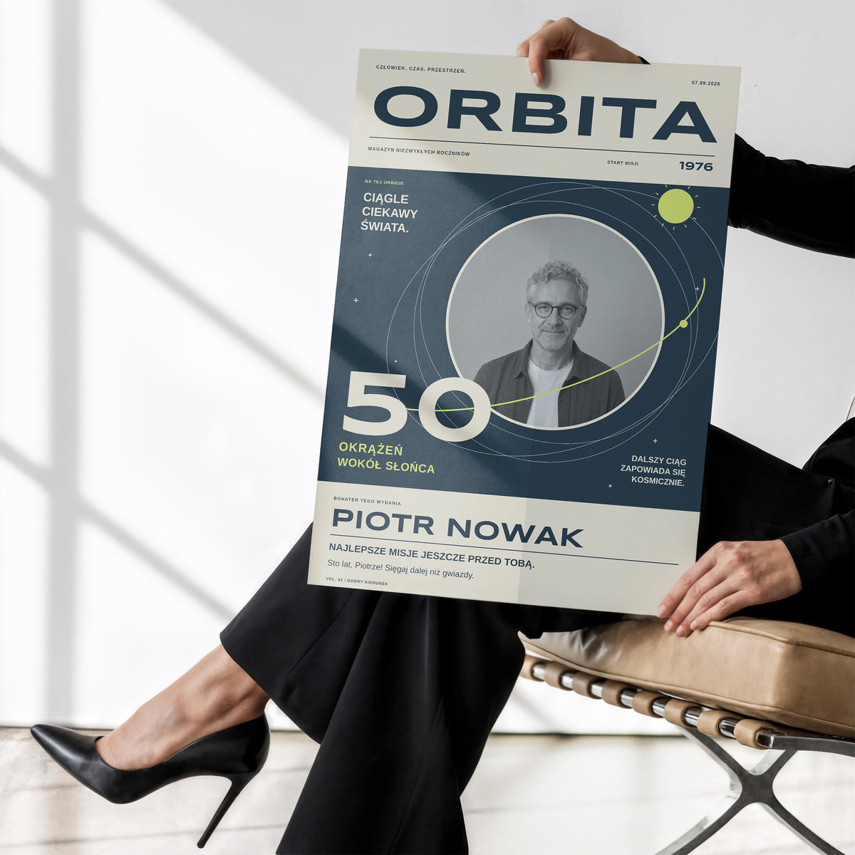 Plakat urodzinowy ORBITA bez ramki trzymany w dłoniach, okrążenia wokół Słońca i fotografia w okrągłym kadrze | C-PL-COVMAG-9-2130-NF