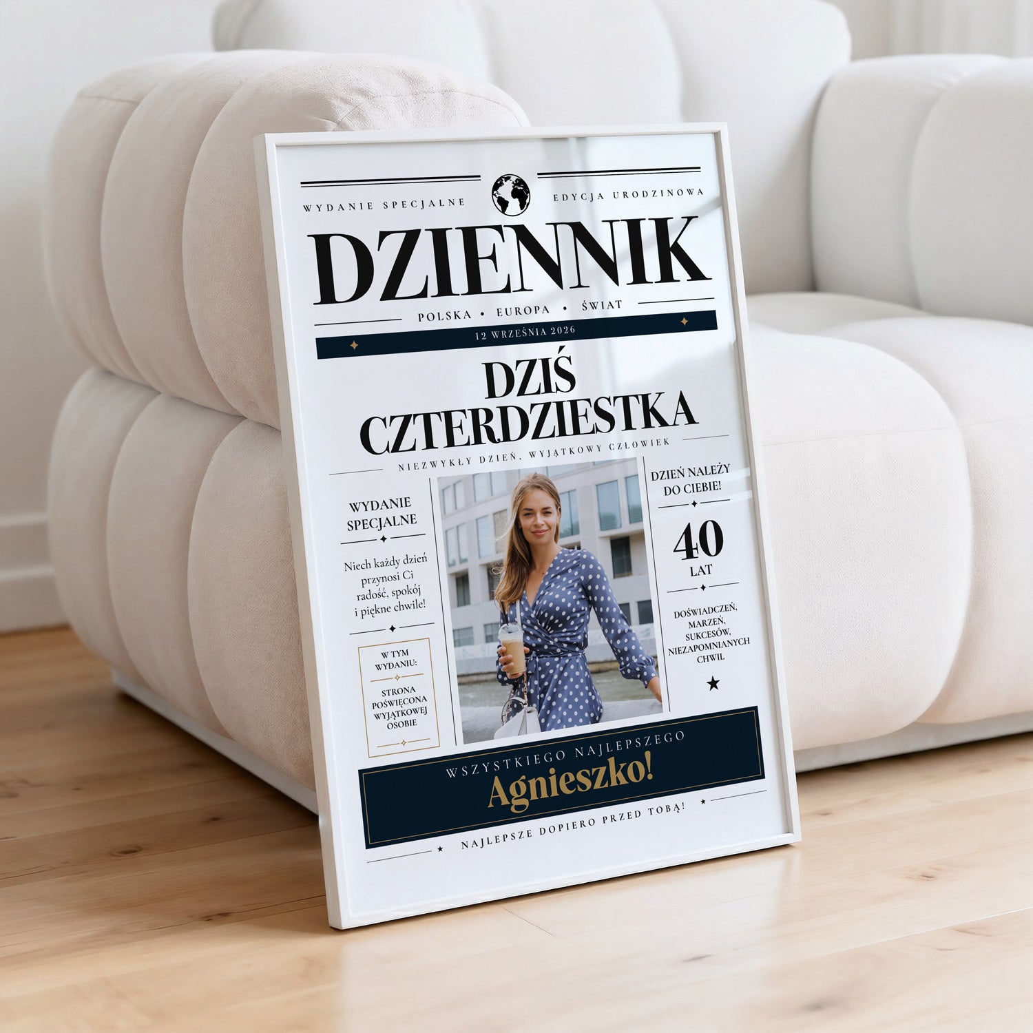 Personalizowany plakat na urodziny dziennik w białej ramce oparty o jasną pikowaną kanapę
