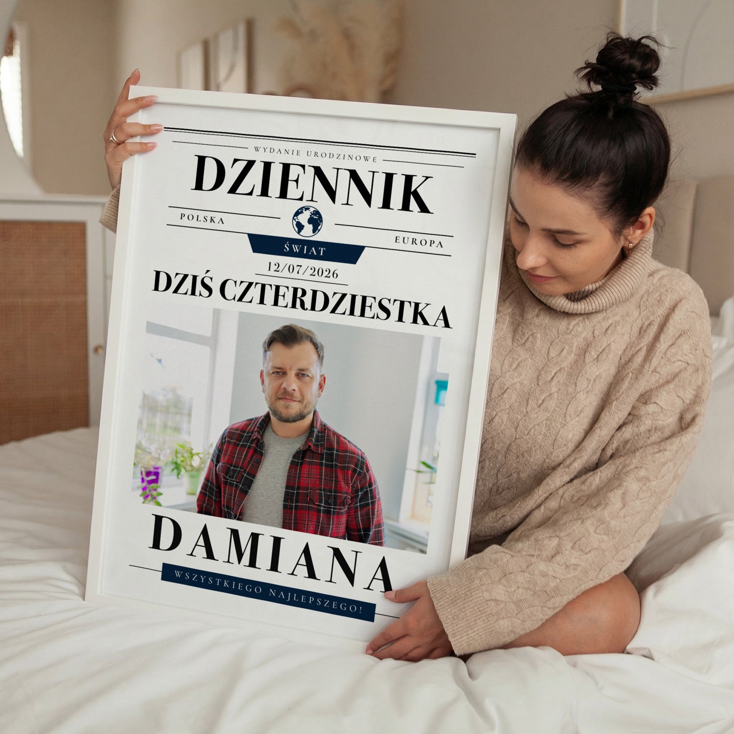 Personalizowany plakat na urodziny w stylu dziennika w białej ramce trzymany przez kobietę w sypialni