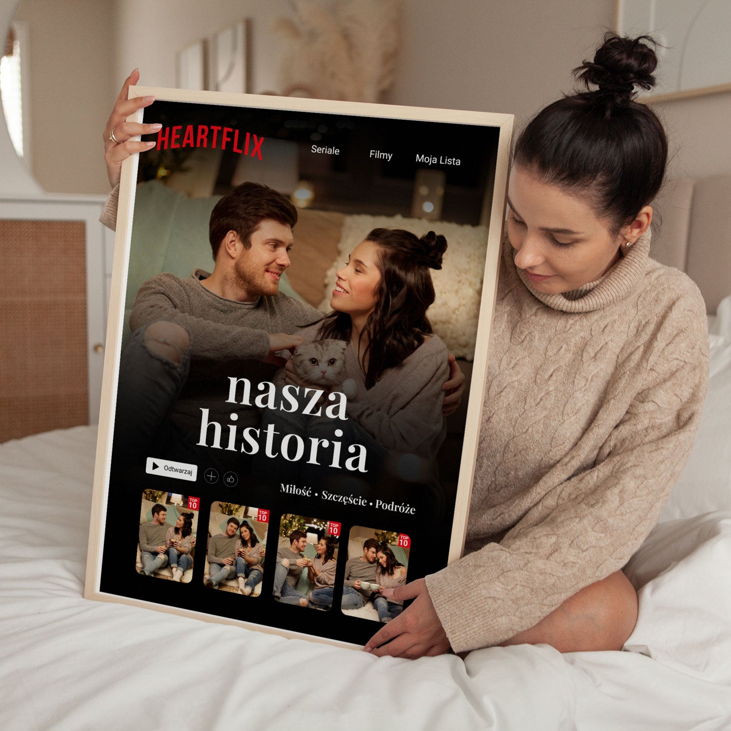 Plakat Heartflix w jasnej ramce trzymany przez kobietę w sypialni