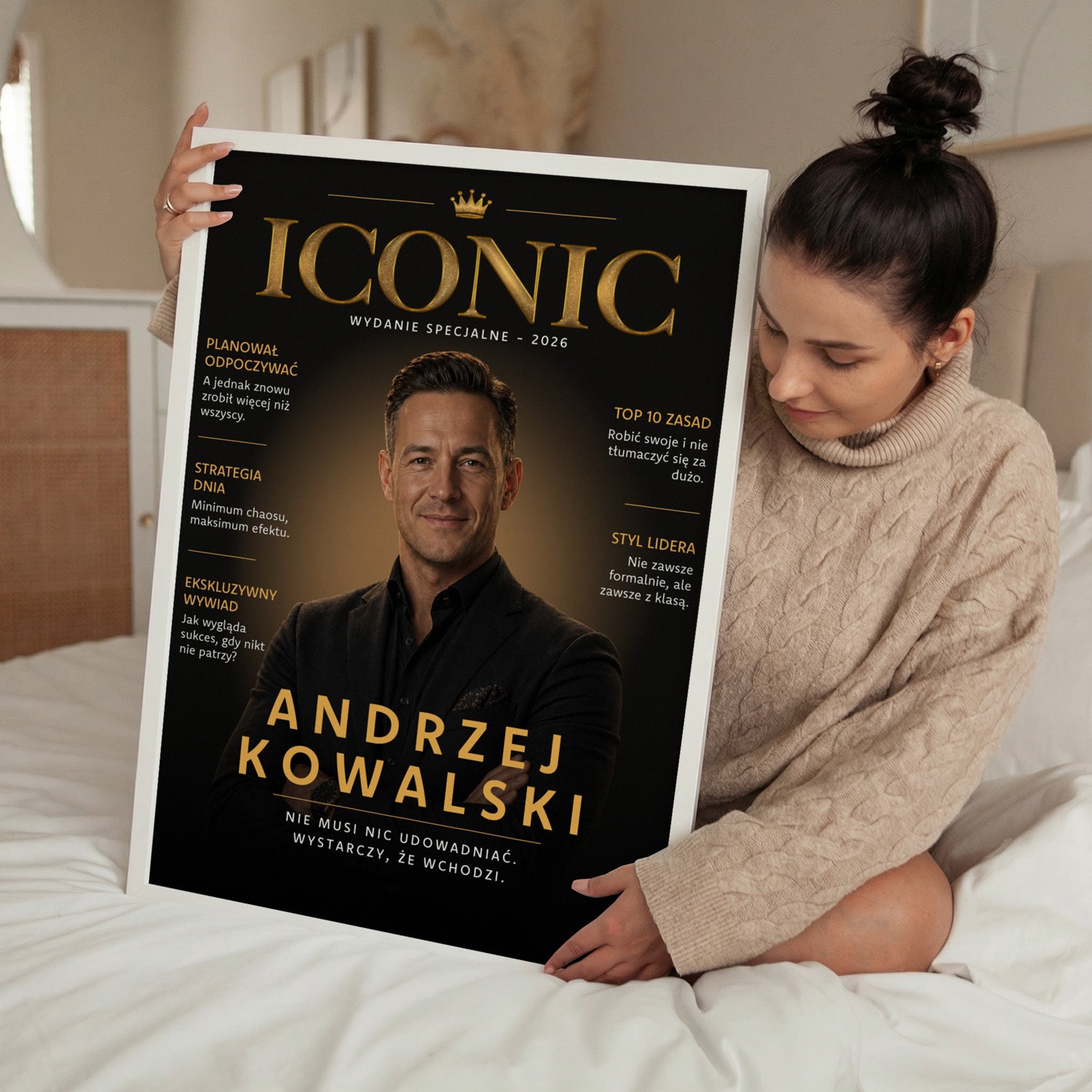 Personalizowany plakat magazynowy Iconic w białej ramce trzymany przez kobietę w sypialni
