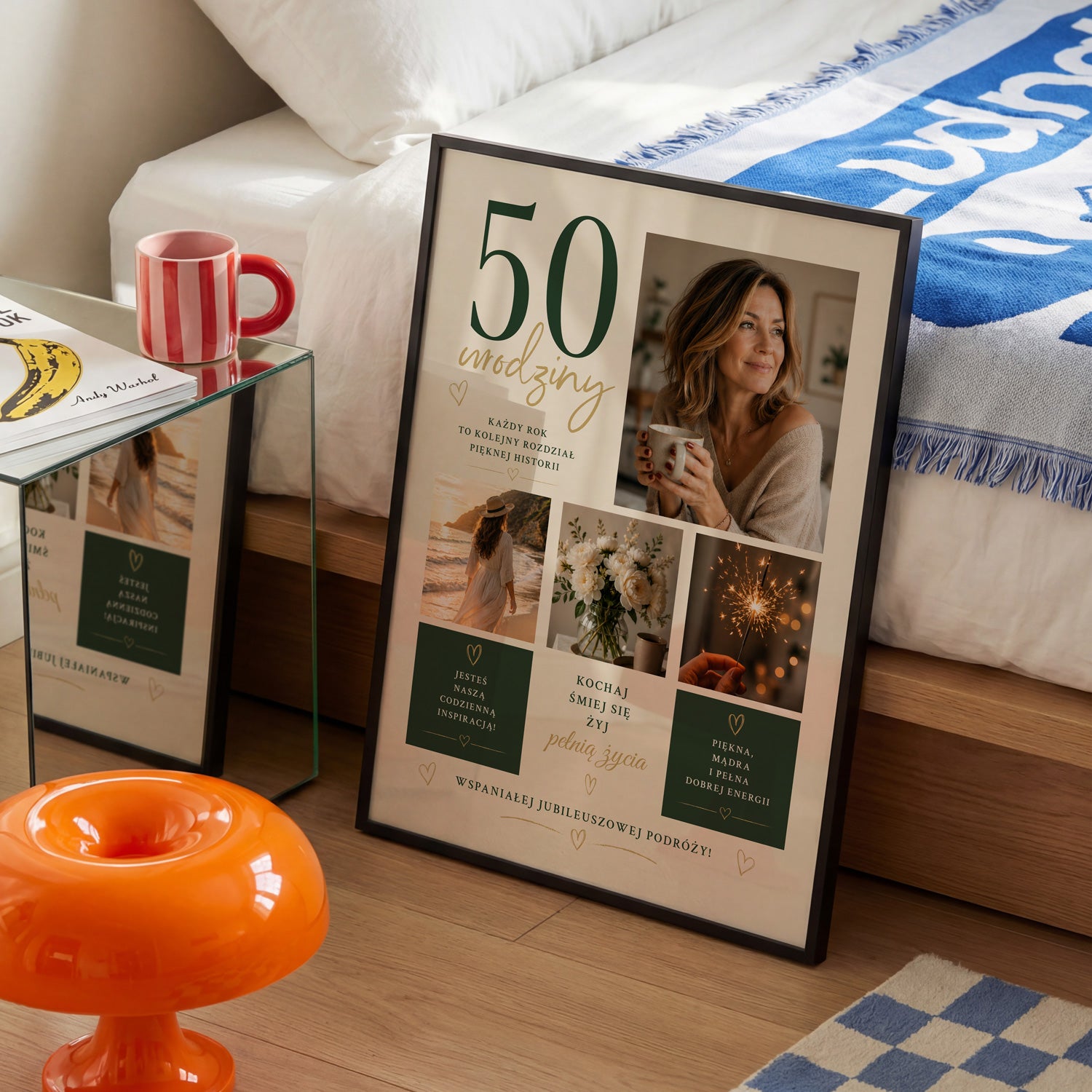 Personalizowany plakat na 50 urodziny dla niej w czarnej ramce, ustawiony w sypialni obok łóżka i czerwonego kubka