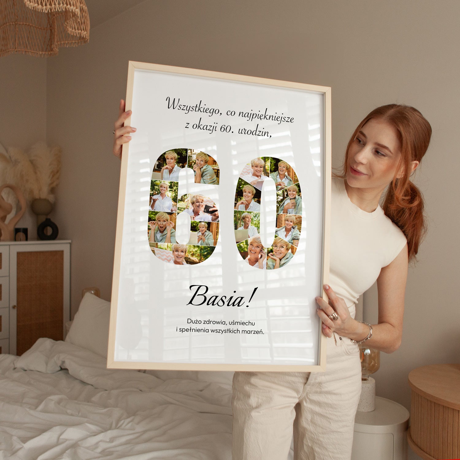 Plakat na 60 urodziny w jasnej drewnianej ramce z kolażem zdjęć trzymany przez kobietę w sypialni