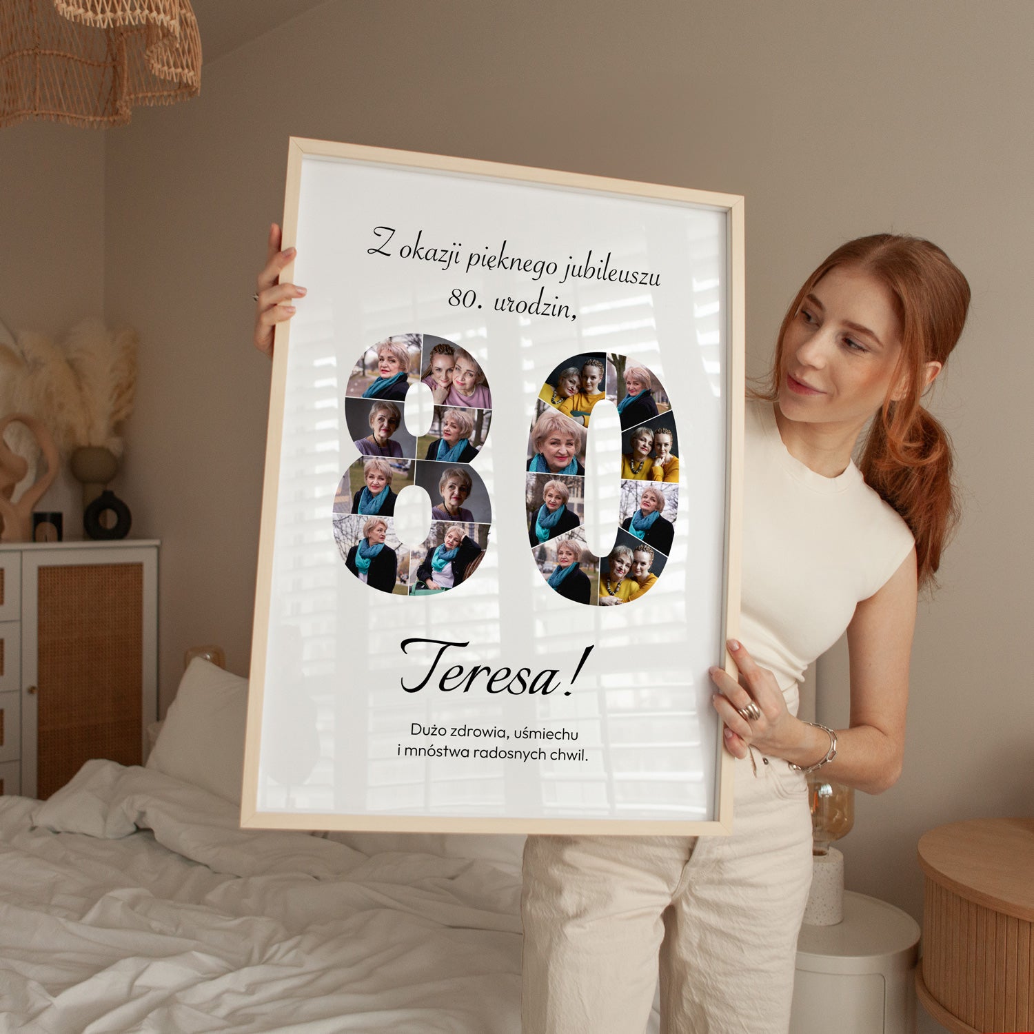 Plakat na 80 urodziny w jasnej drewnianej ramce z kolażem zdjęć trzymany przez kobietę w sypialni