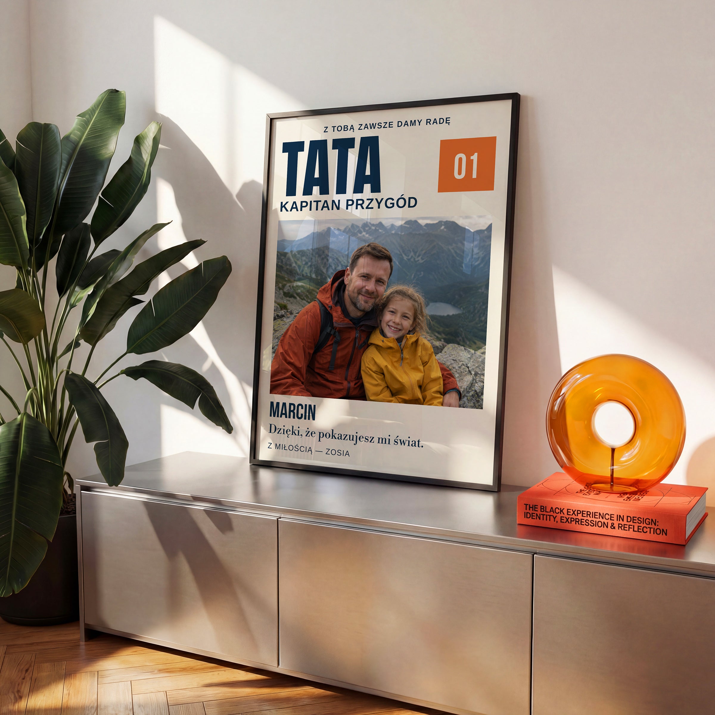 Personalizowany plakat TATA — KAPITAN PRZYGÓD w czarnej ramce na komodzie, z własnym zdjęciem i tekstem | C-PL-HEART-22-2130-NF