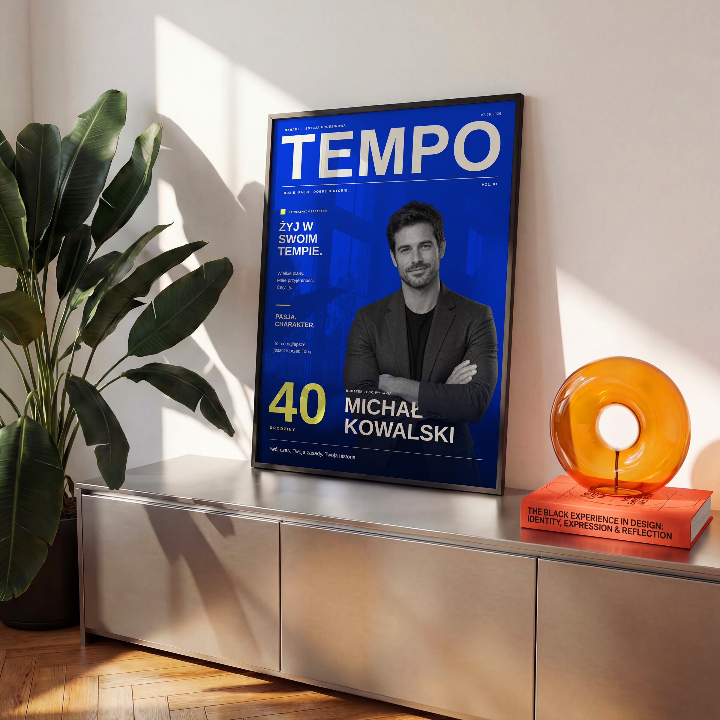 Kobaltowa okładka magazynu TEMPO ze zdjęciem i własnym tekstem w czarnej ramce na komodzie, obok rośliny w słonecznym wnętrzu | C-PL-COVMAG-4-2130-NF