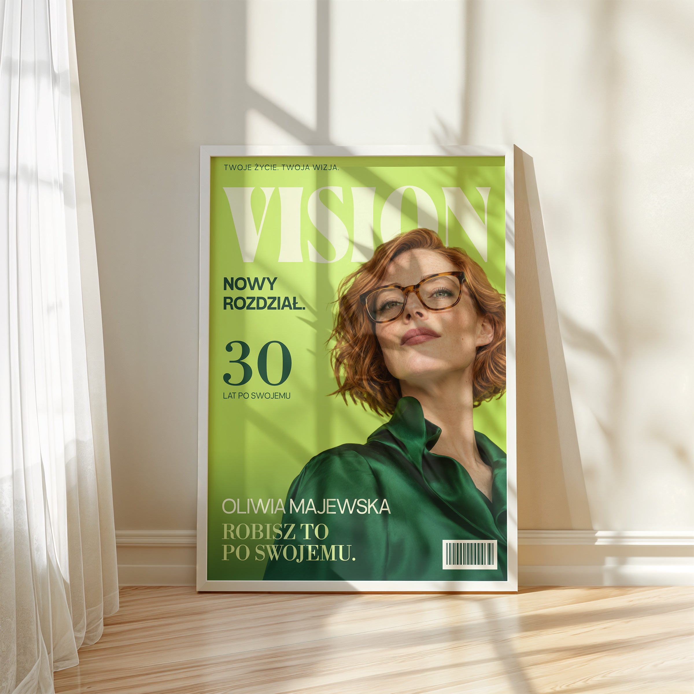 Personalizowany plakat VISION — PO SWOJEMU w białej ramce przy oknie, z własnym portretem, imieniem i napisami na okładce magazynu.