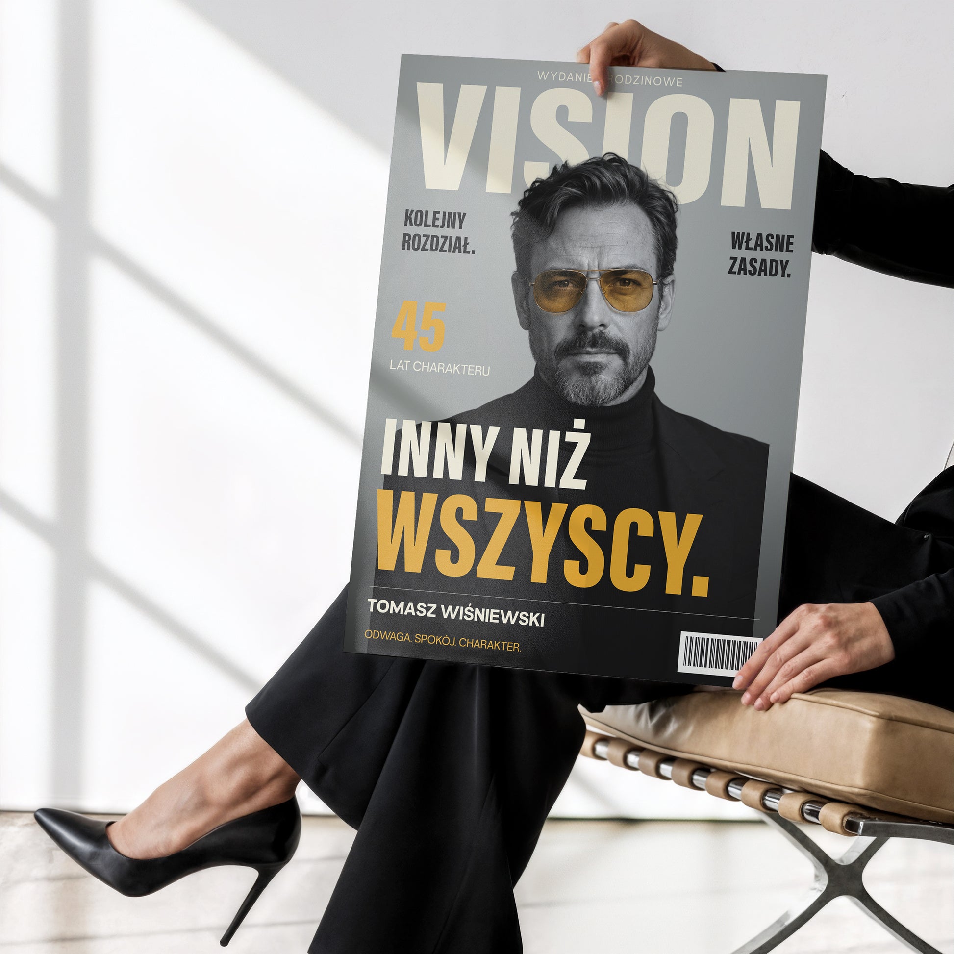 Personalizowany plakat VISION — WŁASNE ZASADY bez ramki, trzymany w dłoniach, z własnym portretem, imieniem i napisami na okładce magazynu.
