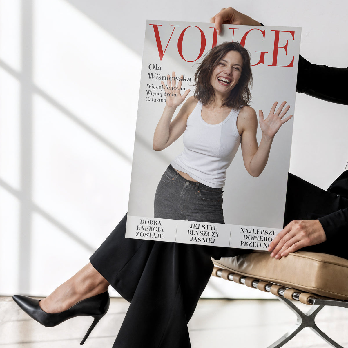 Personalizowany plakat Vouge Radość bez ramki, trzymany w dłoniach. Jasne tło, czerwony tytuł i portret na modowej okładce portretowej.