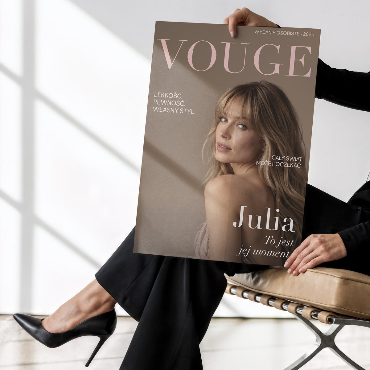 Personalizowany plakat Vouge Jej Moment bez ramki, trzymany w dłoniach. Ciepłe tło taupe, portret i pudrowy tytuł Vouge.