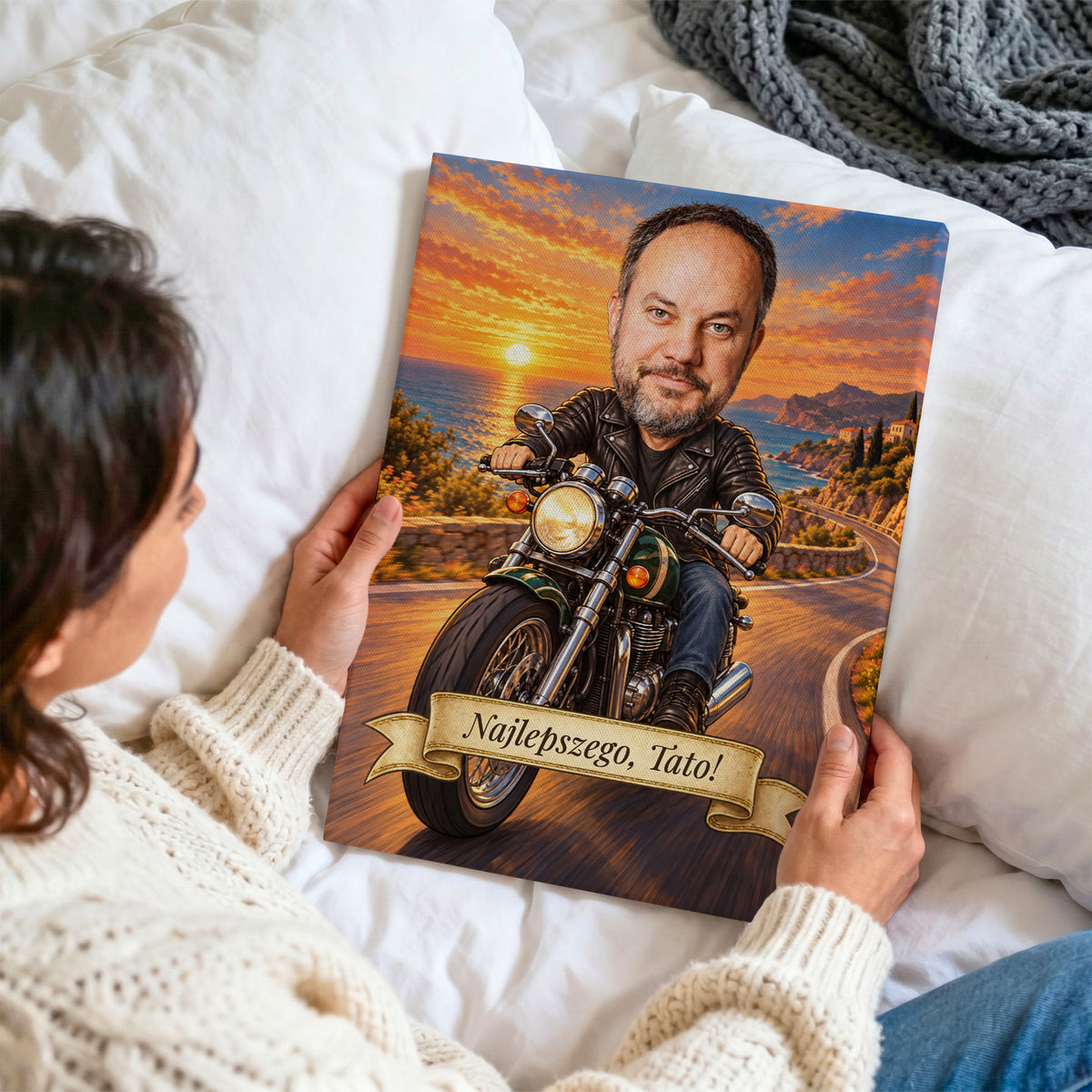 Motocyklista – personalizowana karykatura z dedykacją na płótnie oglądana z bliska w dłoniach na tle jasnej pościeli C-CV-KAR-06-2030
